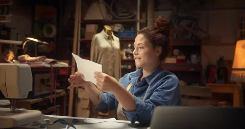 Cheerful inspired female designer using scissors to cut out paper shape for new Stock Footage 140726500