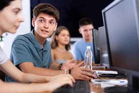 Cheerful interested guy using computer in student library 库存照片