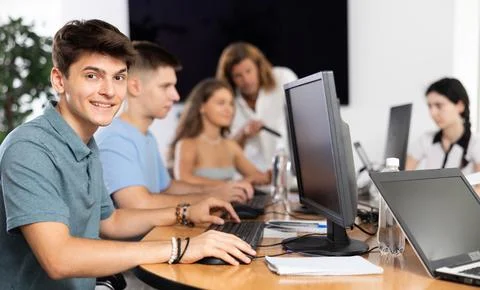 Cheerful interested guy using computer in student library 스톡 사진