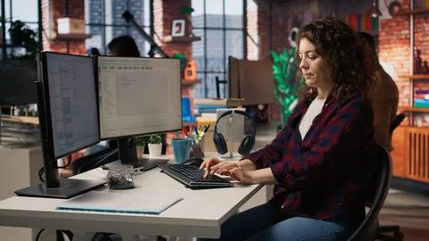 Cheerful IT expert using programming languages on PC in IT startup office 库存照片