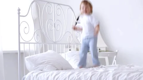Cheerful kid jumping on the bed Video stock 45925590