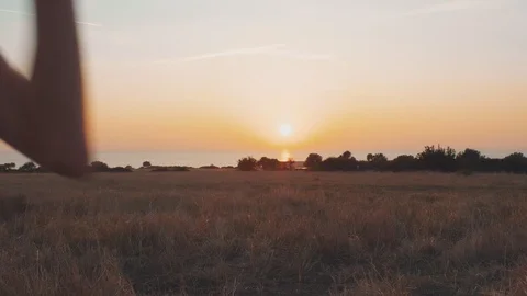 Cheerful kid throwing paper plane into sunset sky outdoors Stock Footage 129422957