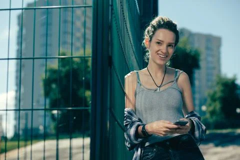 Cheerful lady looking confident while holding her smartphone Stock Photos