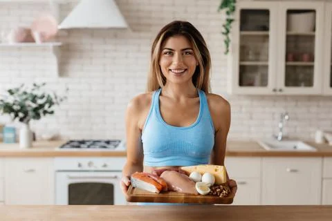 Cheerful lady posing with a selection of protein-filled food Stock Photos