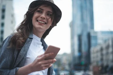 Cheerful lady is using smartphone outside Stock Photos