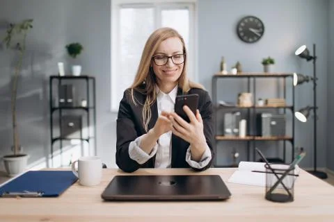 Cheerful lady using smartphone to solve business issues Foto stock