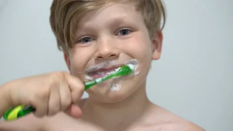 Cheerful little boy brushing teeth in front of the bathroom mirror Stock Footage 160201515