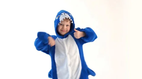 Cheerful little boy dancing fun on a white background in pajamas kigurumi, blue Stock Footage 101031547