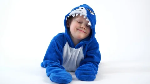 Cheerful little boy posing on a white background in pajamas kigurumi, blue shark Stock Footage 101050967