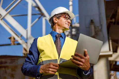 Cheerful male engineer using notebook at factory Stock Photos