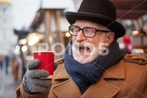 Cheerful male pensioner enjoying hot drink outdoor Stock Photos