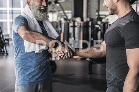 Cheerful males are talking in athletic center Stock Photos