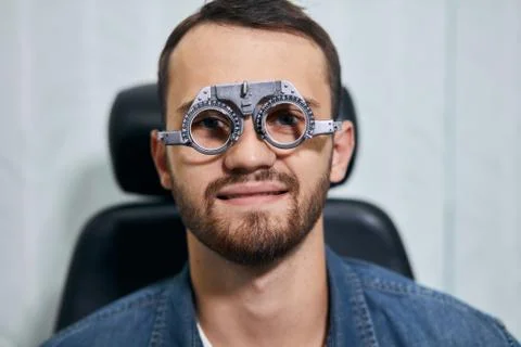 Cheerful man is being checked vision at eye clinic or optics store Stock Photos