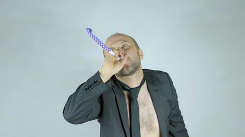 Cheerful man in a cap blows in a festive tune. Vídeo Stock 102965532