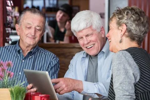 Cheerful Man in Coffee House using Tablet Computer Stock-Fotos