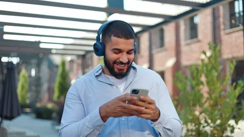 Cheerful man dancing with hands and enjoying drive music via remote earbuds Stock Footage 250389651