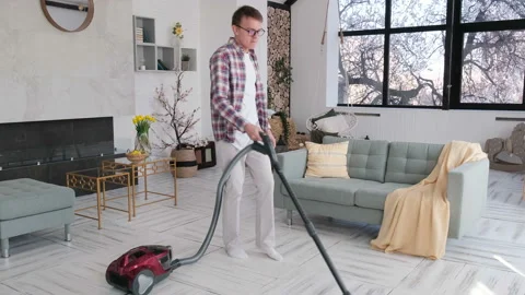 Cheerful man doing the cleaning and dancing with a vacuum cleaner Video stock 127778664