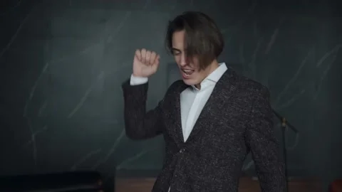 Cheerful man in an expensive suit dancing and singing in the office Stock Footage 168646498