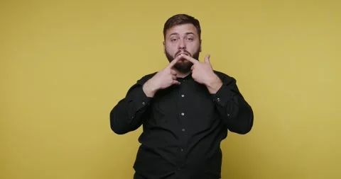 Cheerful man expresses joy and humor against a vibrant yellow backdrop whil.. Stock-Footage 329110952
