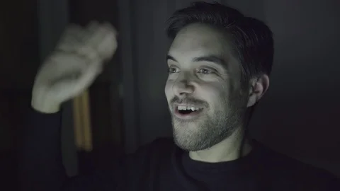 Cheerful man having video conversation at night Video stock 100548780