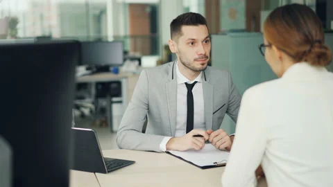 Cheerful man interviewer is talking to female candidate for job vacancy sitting Stock Footage 100249662
