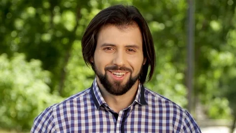 Cheerful man is looking on camera and smiling. He is laughint out loud. Man is Stock Footage 99740127