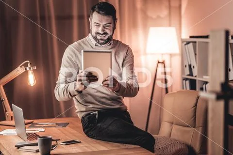 Cheerful man looking at the picture on social media Stock Photos