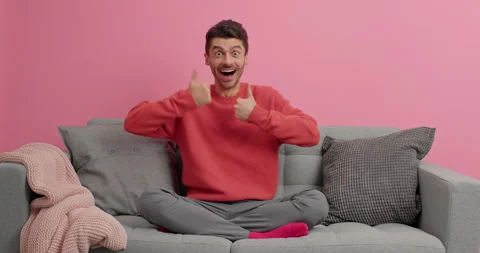 Cheerful man makes thumbs up gesture gives excellent sign poses happy on Stock Footage 143624374