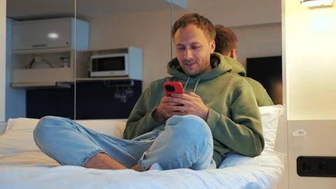 Cheerful man making video call on mobile phone at home. Happy guy talking and 스톡 동영상 240627049