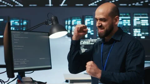 Cheerful man pleased after using PC to fix server cabinets errors in data center Stock Footage 274548062