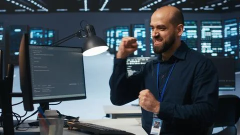 Cheerful man pleased after using PC to fix server cabinets errors in data center 스톡 사진
