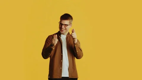 Cheerful man pointing finger choosing you on yellow background Stock Footage 289565342