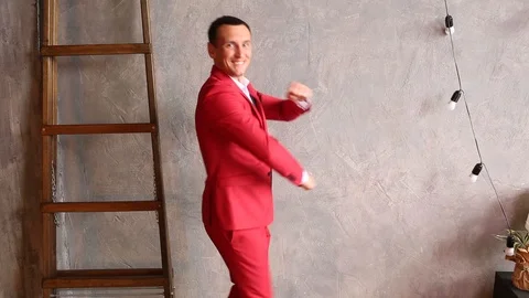 A cheerful man in a red suit dances Stock Footage 88313637