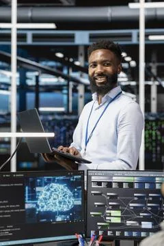 Cheerful man in server hub facility using artificial intelligence Foto stock