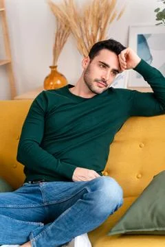 Cheerful man sitting on sofa Stock Photos