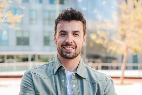 Cheerful man smiling confidently while enjoying a sunny day outdoors in a Stock Photos