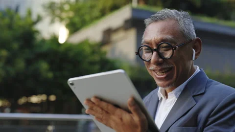 Cheerful Man Talking Online on a Tablet While Standing on the Street. Asian Stock Footage 276720504
