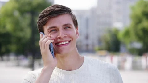 Cheerful man talking on phone in city park Stock Footage 159002553