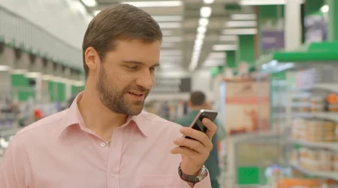 Cheerful man using mobile phone in store Stock Footage 63365088