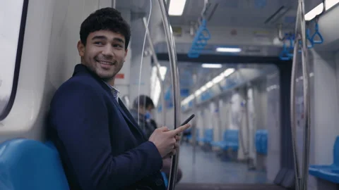 Cheerful man using smartphone for online chatting at metro Stock Footage 154312465