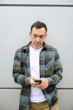 Cheerful man using smartphone in room Stock Photos
