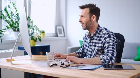 Cheerful man working on computer from home 動画素材 126829599