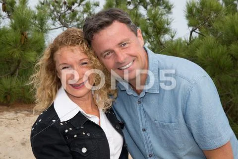 Cheerful mature woman embracing smiling man Stock Photos