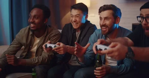 Cheerful Men Friends Resting while playing Video Games using PlayStation at Home Video stock 170315747