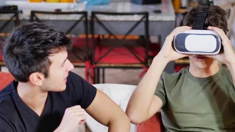 Cheerful men having fun with VR headset Stock Photos