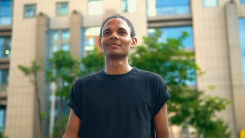 Cheerful mixed race guy walking outdoors Stock Footage 127866166
