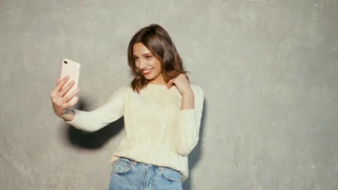 Cheerful model posing near gray wall in studio Stock Footage 146122104