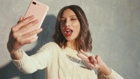 Cheerful model posing near gray wall in studio Stock Footage 146122334