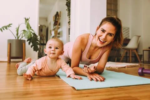 Cheerful mom doing plan exercises with her baby at home Stock-Fotos