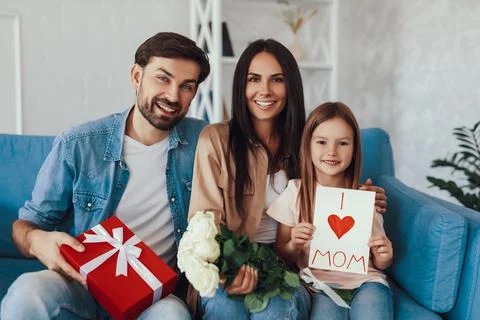 Cheerful mom posing with her mindful husband and caring daughter Stock Photos